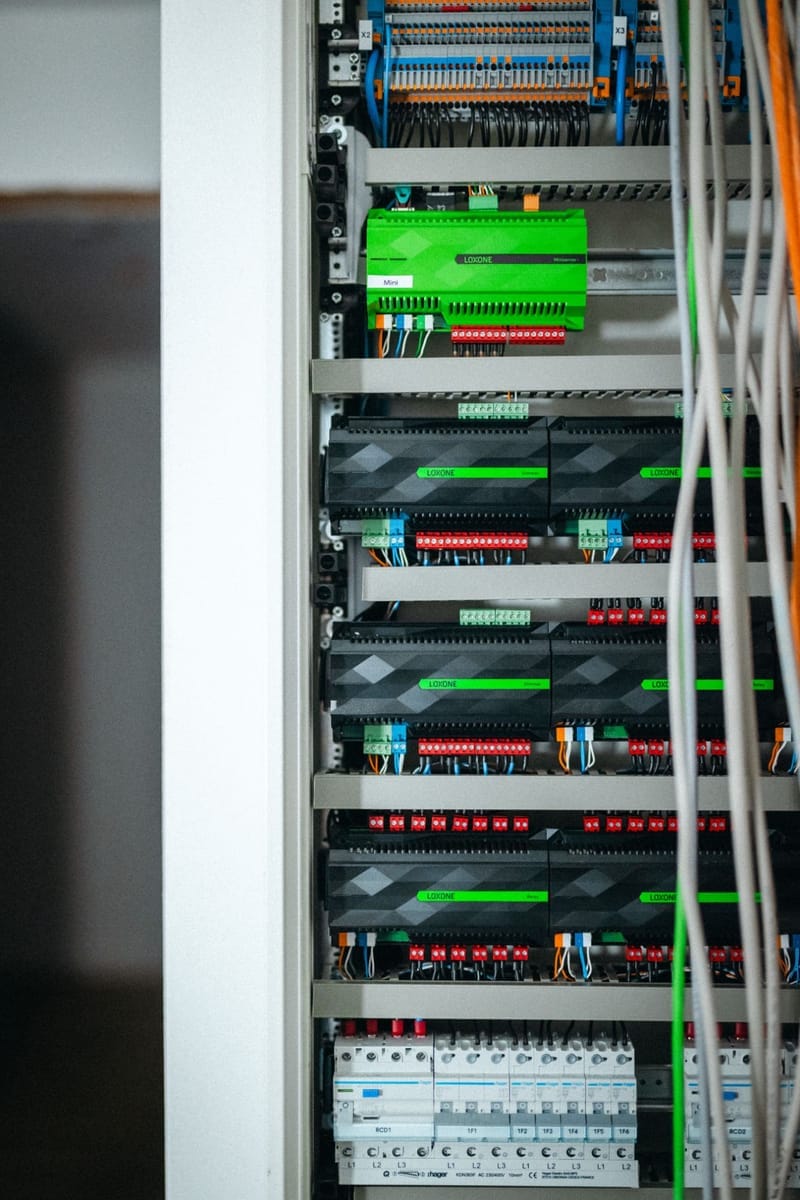 Zbliżenie na Loxone Miniserver oraz moduły Dimmer i Relay zamontowane nad zabezpieczeniami nadprądowymi